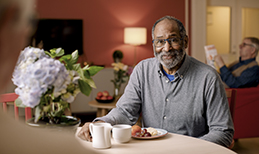 A man eats breakfast in the cafe of his senior care home