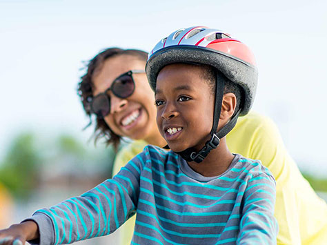 Mom helping son ride his bike