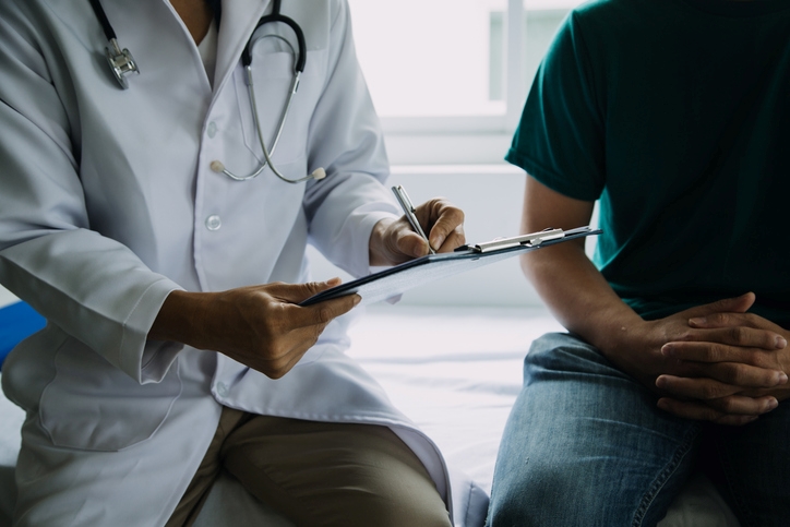 Doctor with patient writing on a clip board
