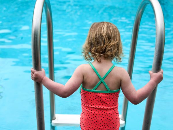 Little girl getting into a pool