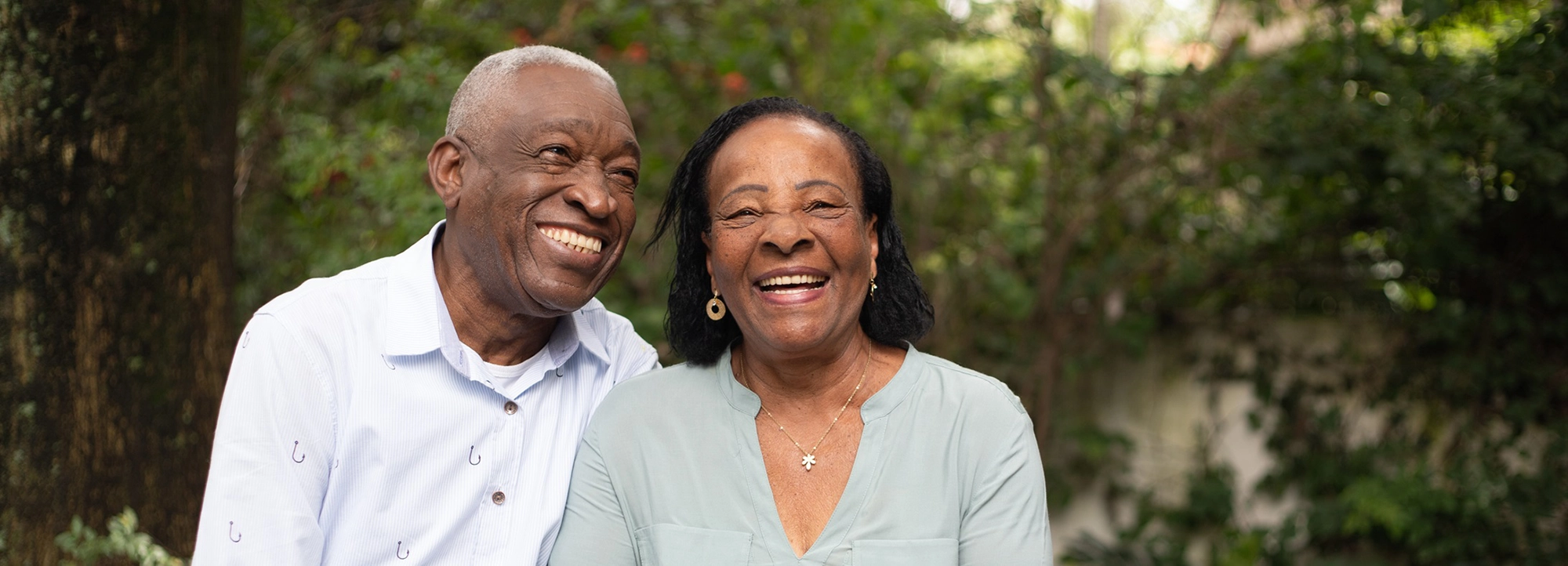 A senior couple smile together outside