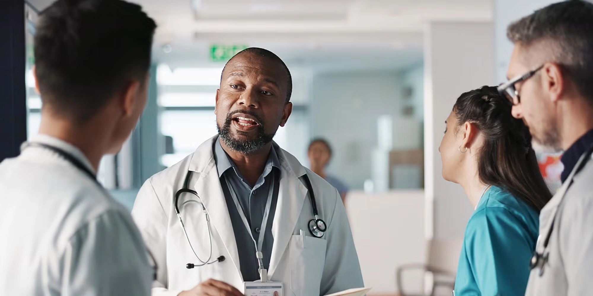 A group of providers talk in a hospital hallway