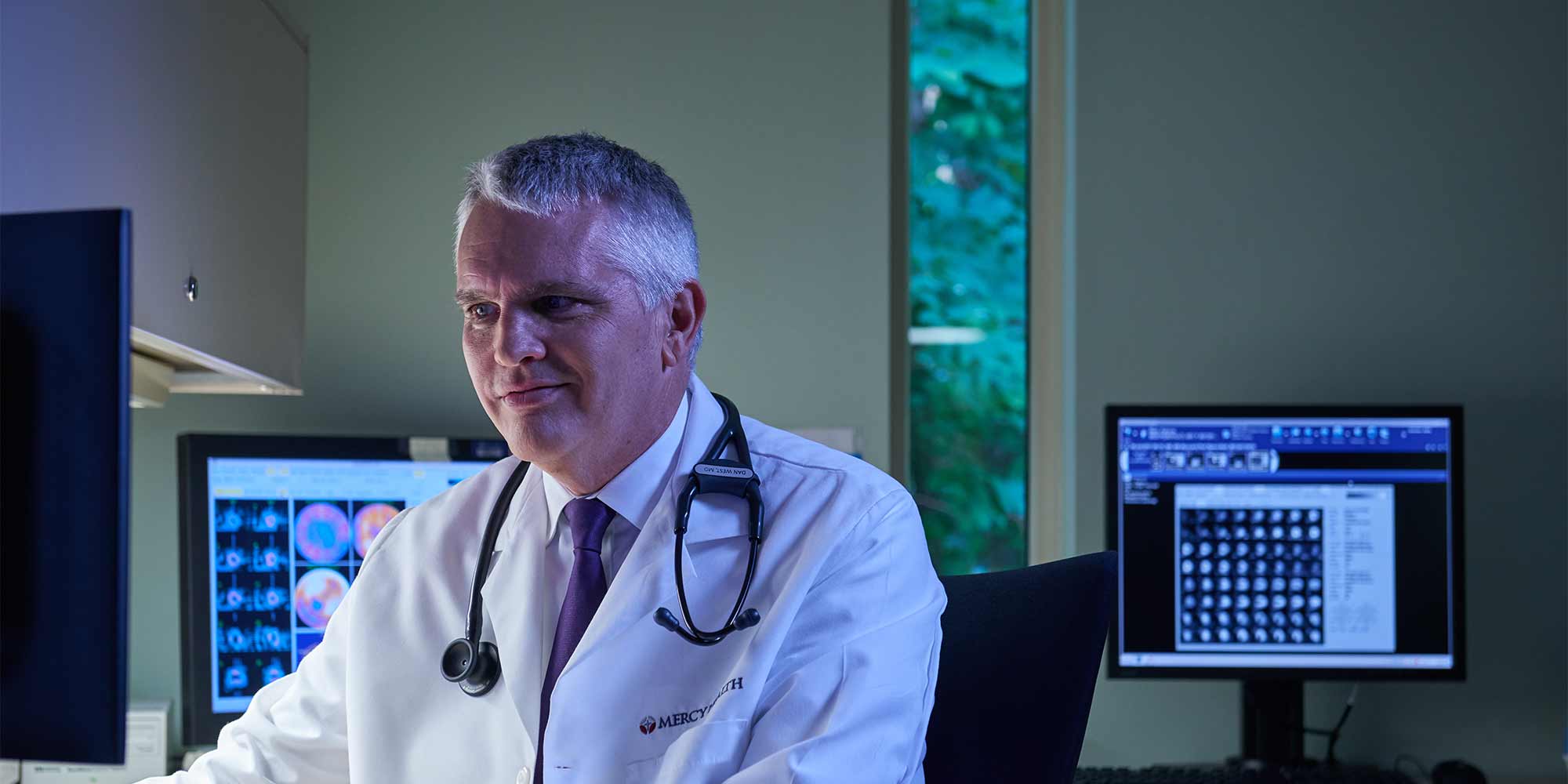 A provider sits at his computer analyzing medical scans