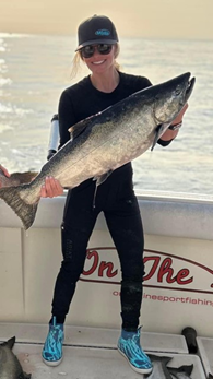 Katie on a fishing boat holding a huge fish.