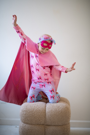 GiGi wears a cape and pretends to fly